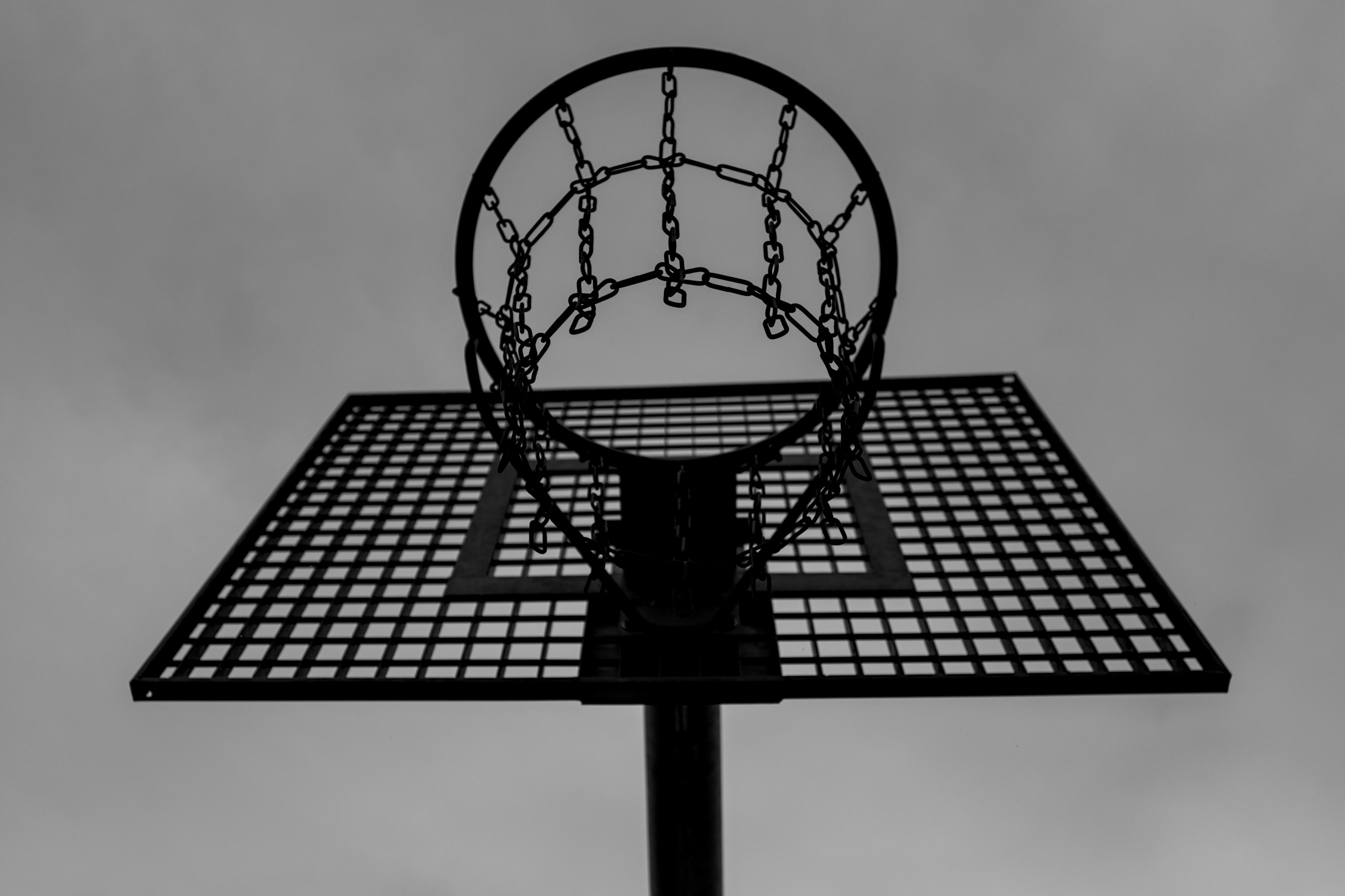 Ein Basketballkorb von unten fotografiert in schwarzweiß